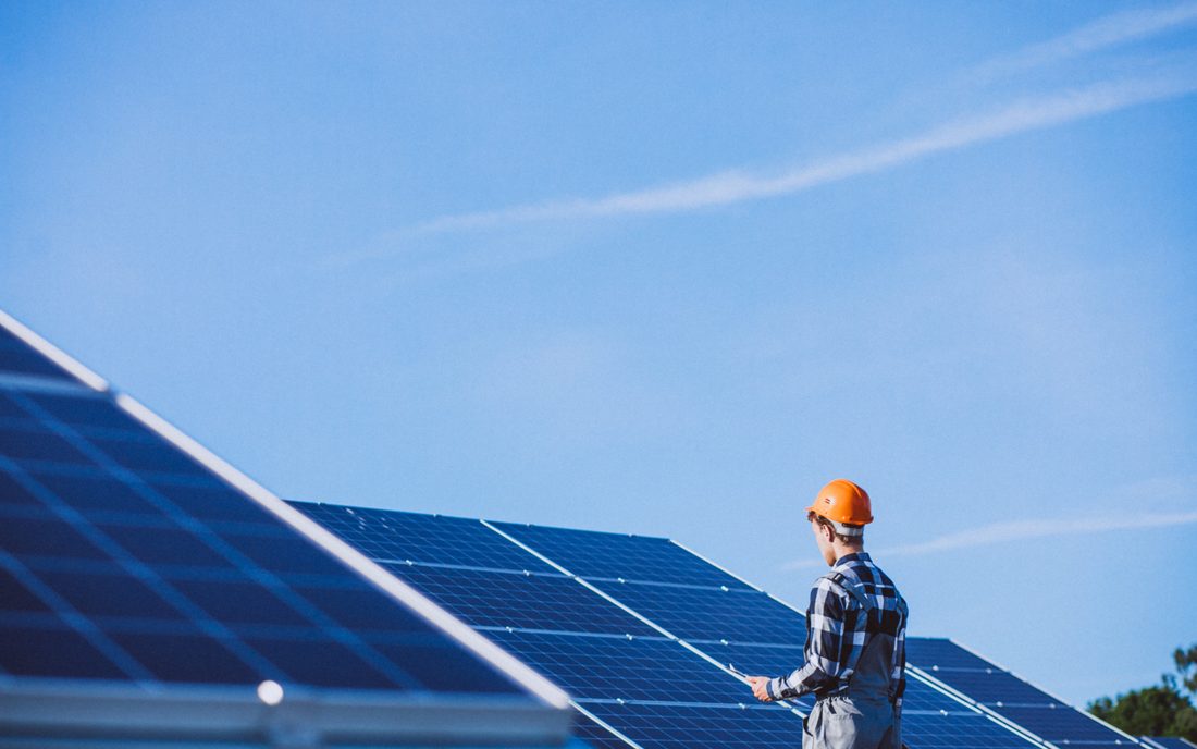 Técnico junto a paneles solares revisando la instalación